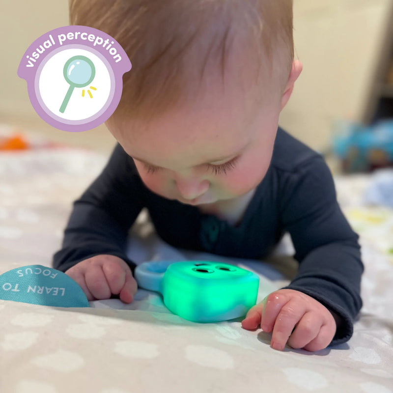 baby during tummy time watching glowing blair rattle
