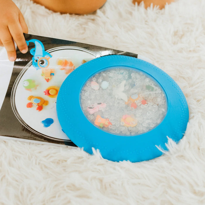 peekaboo sensory bag clipped to a book with child searching for figurines