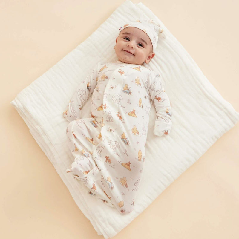 Newborn wearing magnetic gown while lying on blanket