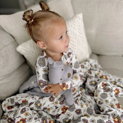 toddler snuggled with gunamuna bouquet sleep bag on sofa