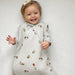 baby wearing gunamuna pooh sleep bag tog 2.5 smiling on white sheet