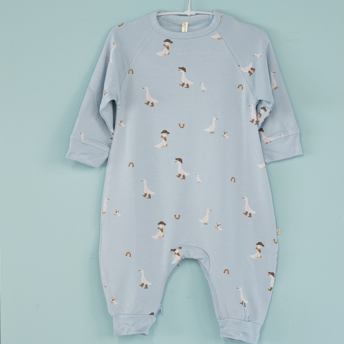 Light blue baby onesie with geese wearing cowboy boots pattern on a light blue background