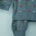 Children's outfit with car pattern on a light blue background