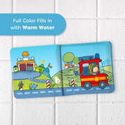 Illustrated book open to two pages with a fire truck and building on a white tiled background.