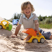 Child playing with a toy digger in the sand