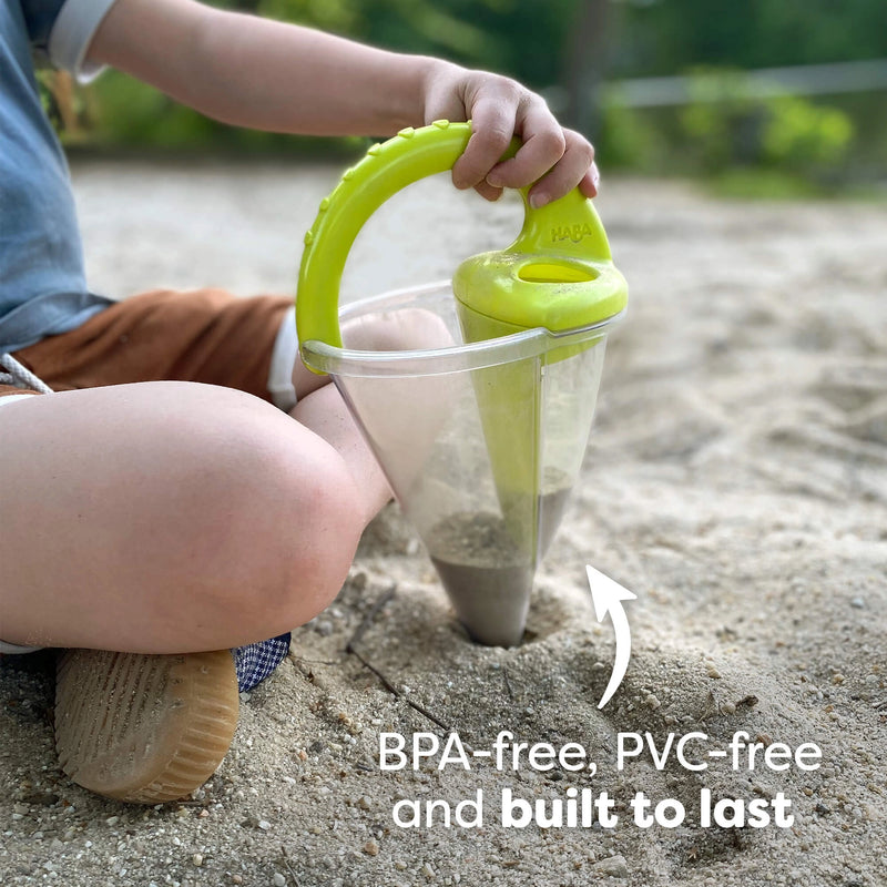 Child playing with a green sand toy in a sandbox, with text indicating BPA-free and PVC-free materials.