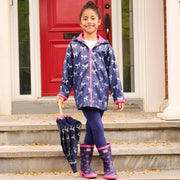 Child wearing navy foil bows rain jacket with matching boots on steps