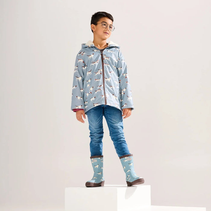 Child wearing blue-grey dog print sherpa-lined rain jacket standing on platform