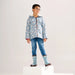 Child wearing blue-grey dog print sherpa-lined rain jacket standing on platform