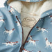 Close-up of cream sherpa lining and zipper on dog print rain jacket
