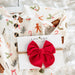 Children's Christmas-themed shirt with a red corduroy bow and LouLou brand card on a white textured background