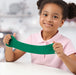 Child stretching bright green Hey Clay while smiling at a table