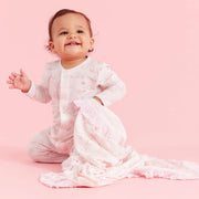 Baby wearing Sweeter Than Hunny magnetic ruffle footie on pink background