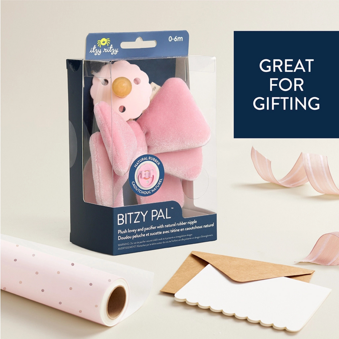 Pink plush toy in packaging with 'Itzy Ritzy' branding on a light background.