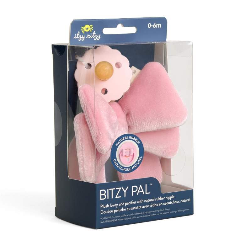 Pink plush bow and pacifier in its packaging, featuring the brand 'itzy ritzy'.
