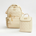 Beige backpack and smaller bag with tassel on a white background
