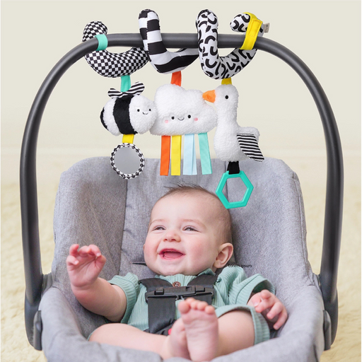 Baby seated in a car seat interacting with the spiral activity toy