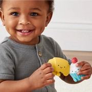 Child holding a soft bakery character from the Itzy Play Bakery activity toy