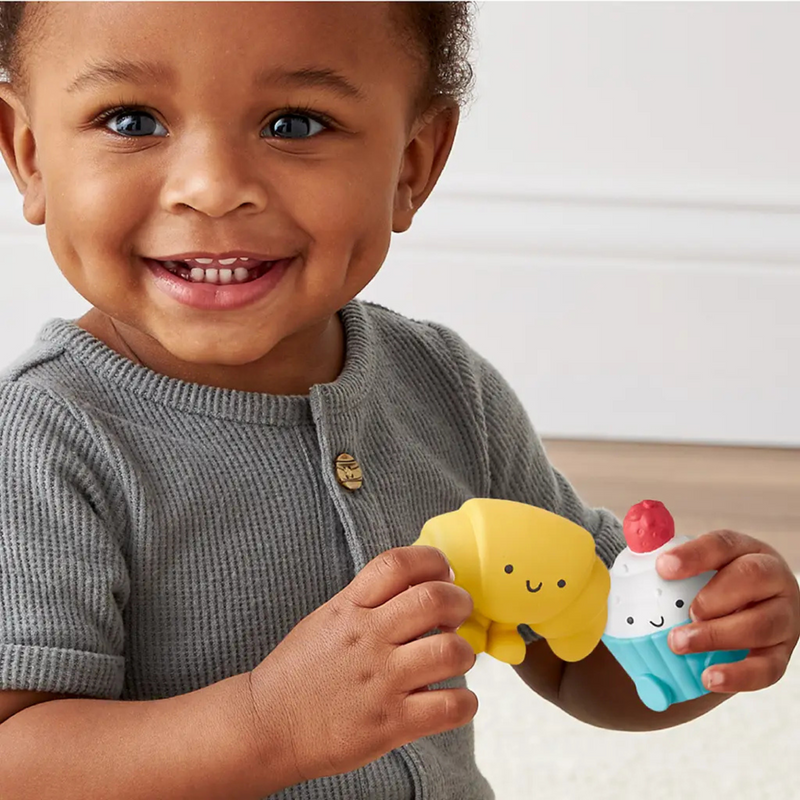 Child holding a soft bakery character from the Itzy Play Bakery activity toy