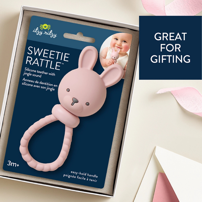 Pink bunny rattle with packaging on a light background