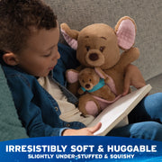 Child reading with Kanga and Roo plush cuddled on a chair