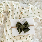 Baby outfit with green tree pattern and green bow headband on a white background