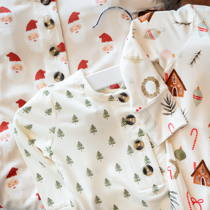 Baby clothes with Christmas-themed patterns on a white background