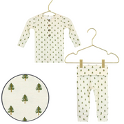 Children's long-sleeve shirt and pants with tree pattern on hangers against a white background.