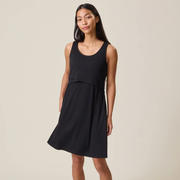 Woman wearing a black sleeveless dress against a beige background