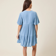 Woman wearing a light blue dress against a beige background