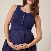 Woman wearing a navy blue dress with a beige background