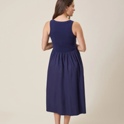 Woman wearing a navy blue dress against a beige background