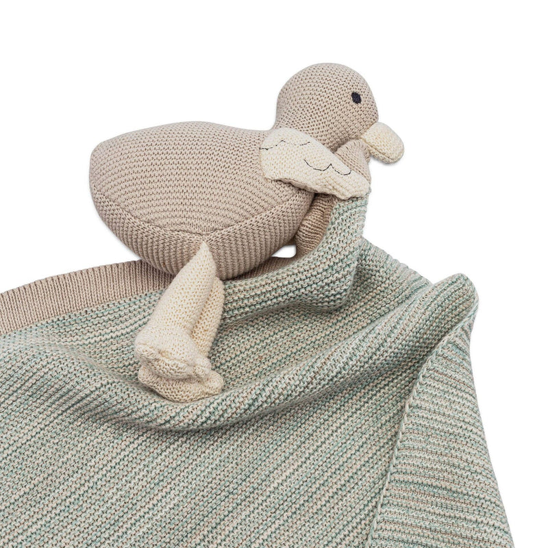 Knitted duck toy on a textured blanket with a white background