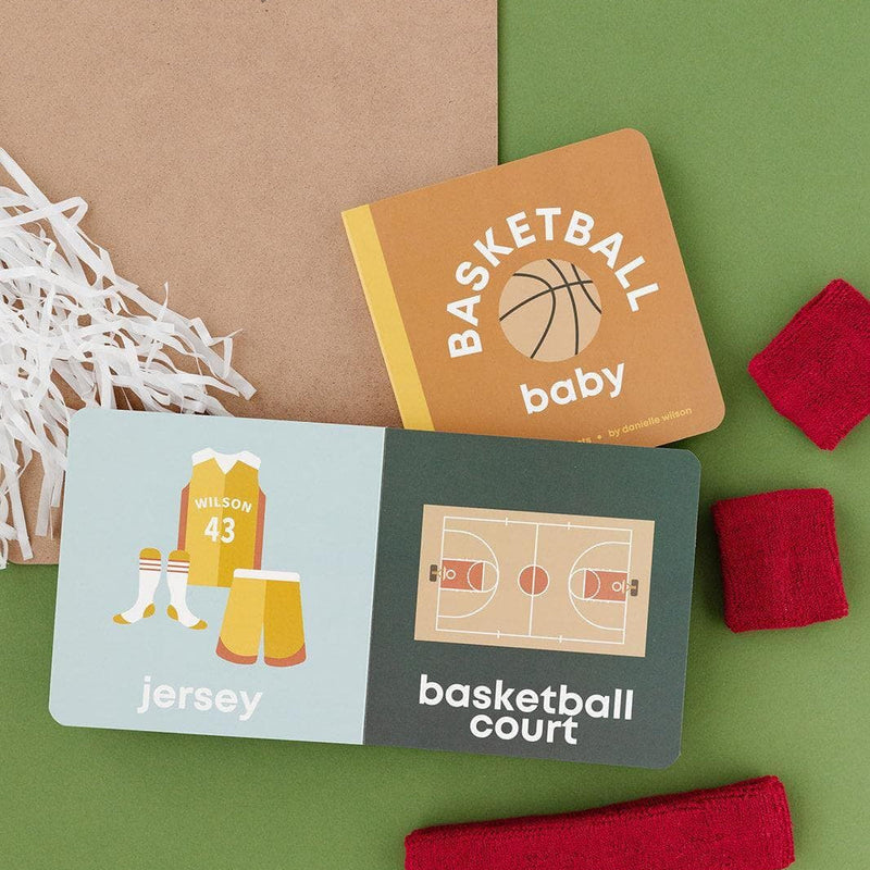 Basketball Baby board book open to the jersey and basketball court pages with a clipboard