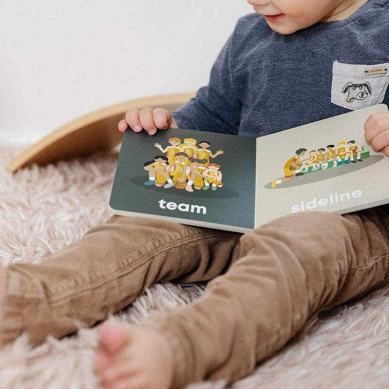 Toddler reading the Basketball Baby board book