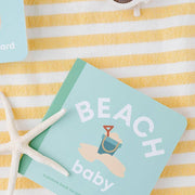 Beach Baby board book on a striped towel with sunglasses and a starfish
