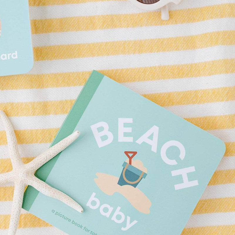 Beach Baby board book on a striped towel with sunglasses and a starfish