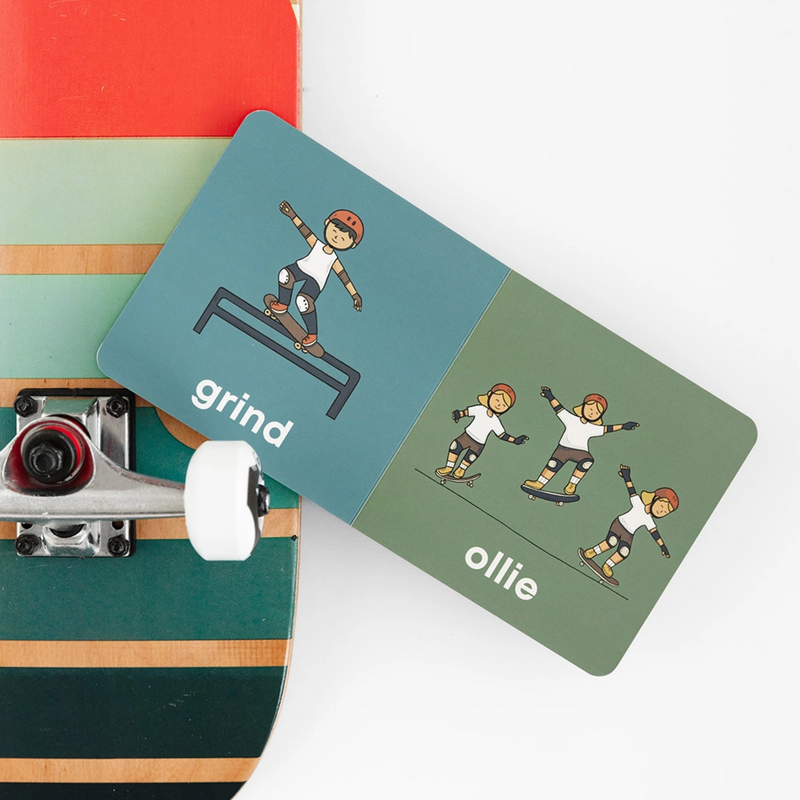 Skater Baby board book open to the grind and ollie pages on a skateboard