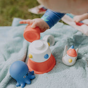 Child playing with colorful toys on a blanket outdoors