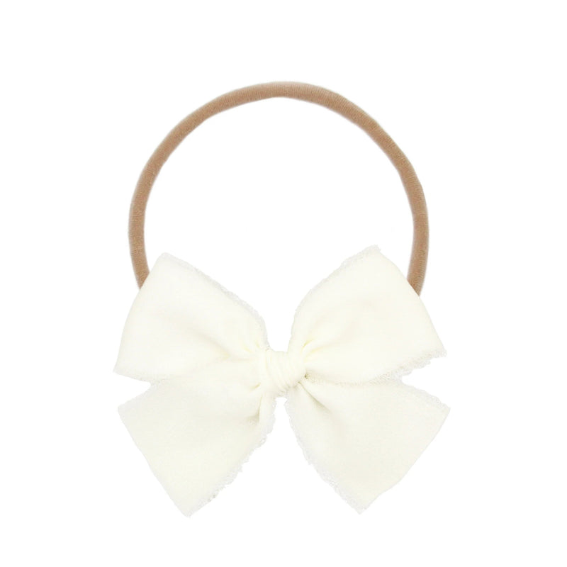 Cream-colored bow hair elastic on a white background
