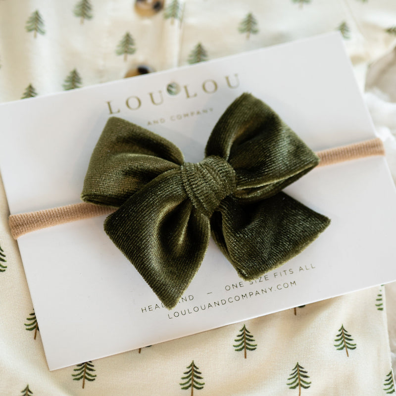 Olive green velvet bow headband on a LouLou brand card with a patterned background