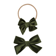 Two olive Lou Lou & Co hair bows on a white background