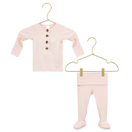 Pink baby outfit with long-sleeve top and pants on gold hangers against a white background