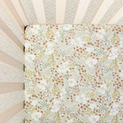 Floral patterned crib sheet inside a crib
