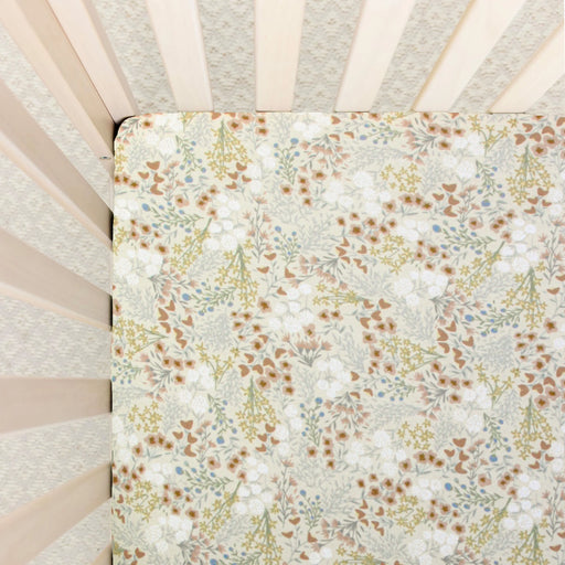 Floral patterned crib sheet inside a crib