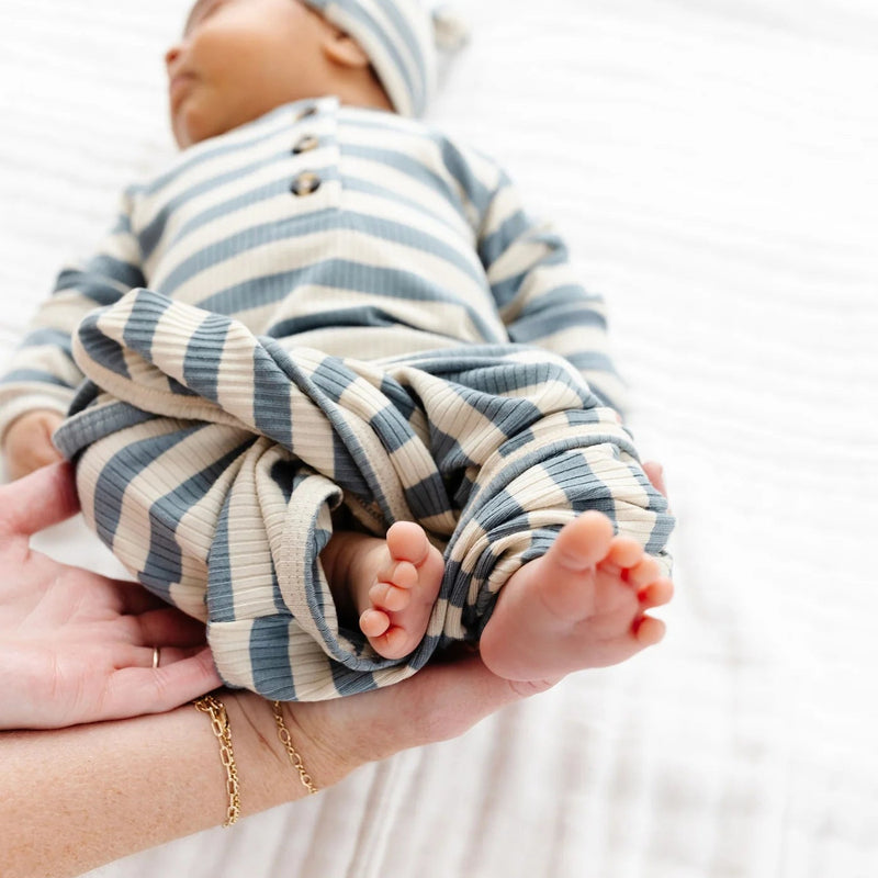Newborn baby wrapped in a striped blanket with a white background