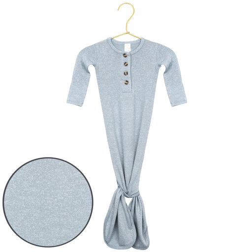 A light heather gray long-sleeve baby tunic with a buttoned henley neckline and a gathered tie at the bottom, shown hanging on a gold hanger with a circular fabric detail inset on the bottom left.