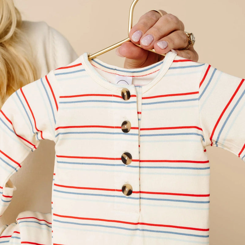 Striped baby outfit on a hanger with a blurred background