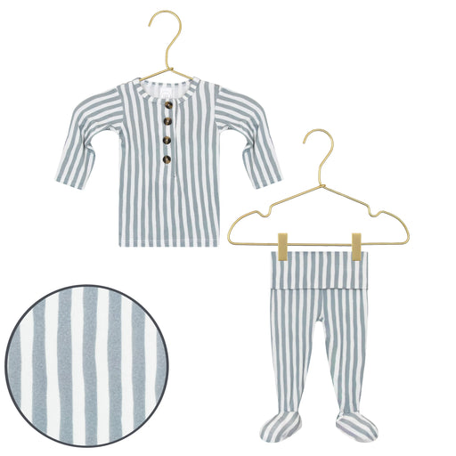 Striped baby outfit with shirt and pants on hangers against a white background