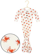 Baby onesie with red crab pattern on a hanger against a white background
